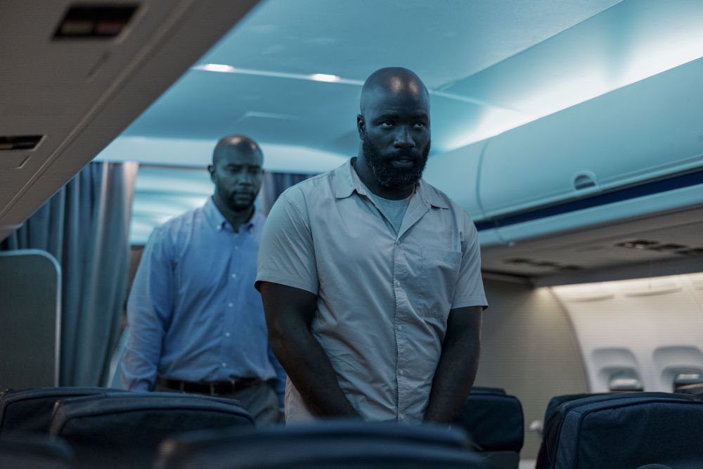 Zwei Schwarze Männer an Bord eines Flugzeugs.